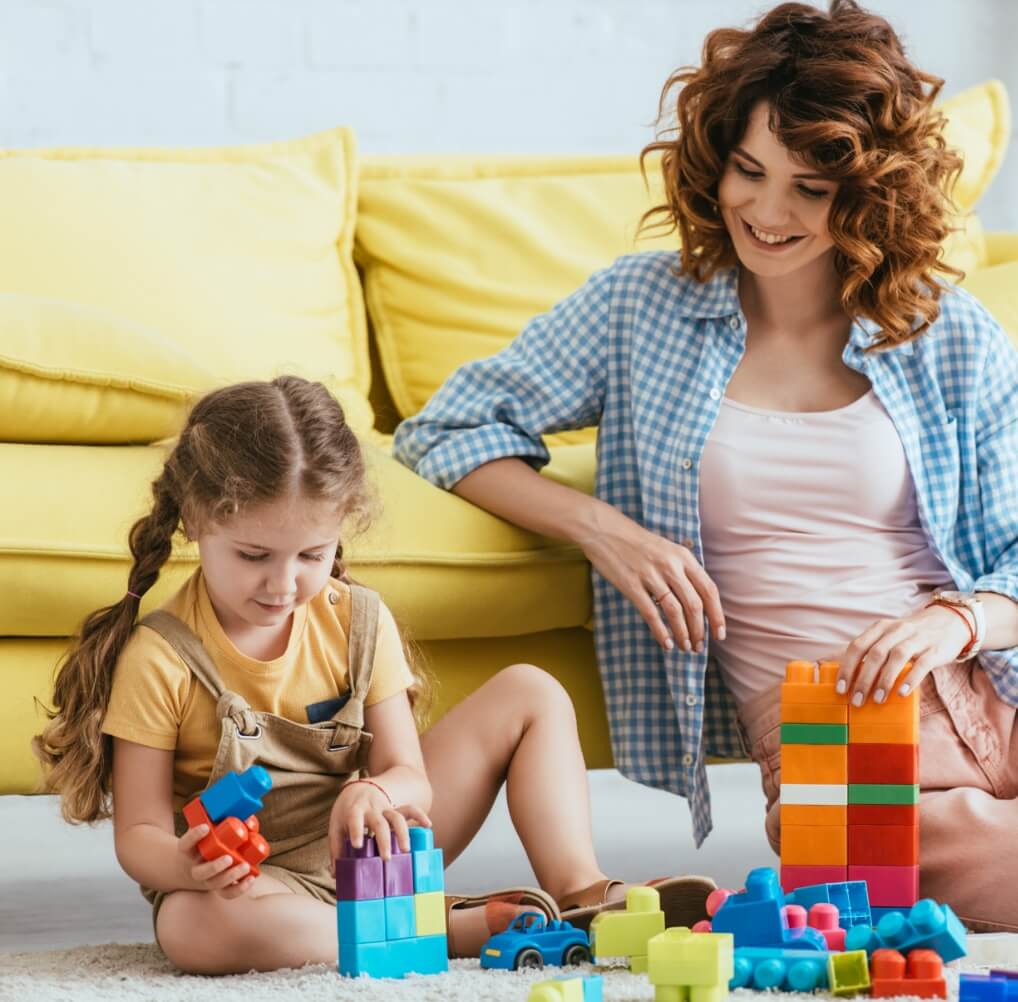 smiling-nanny-and-adorable-kid-playing-with-multic-2023-11-27-05-24-50-utc (1)